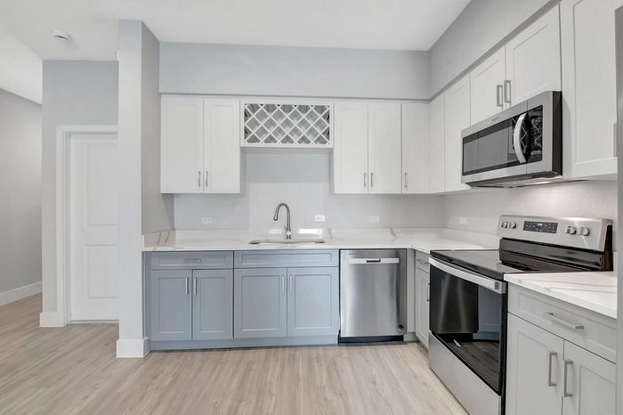 Modern kitchen with sleek cabinetry, stainless steel appliances, and elegant light wood flooring.