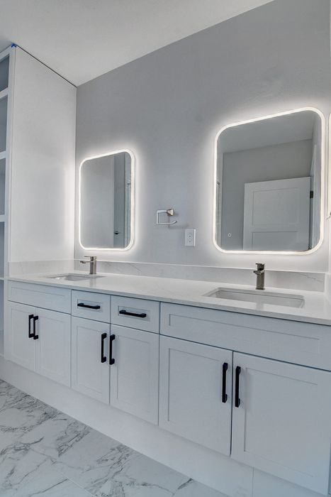 Sleek bathroom design with dual sinks, illuminated mirrors, and elegant cabinetry for modern living.