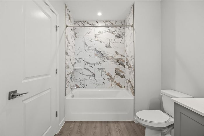 Modern bathroom with elegant marble-tiled shower, sleek bathtub, and contemporary fixtures for a luxurious feel.