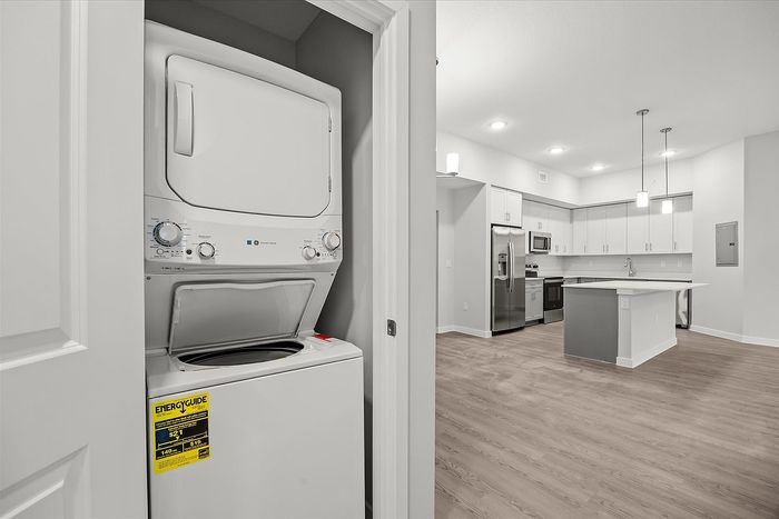 Modern apartment with sleek kitchen, stainless steel appliances, and in-unit laundry, offering convenience and style.