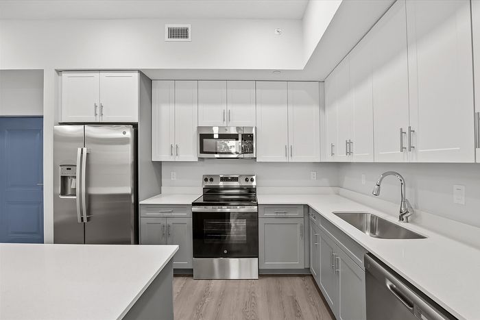 Sleek modern kitchen with stainless steel appliances, white cabinetry, and a spacious countertop for culinary creativity.
