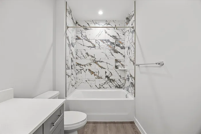 Luxurious bathroom featuring elegant marble tile, a modern bathtub, and sleek fixtures for a sophisticated look.