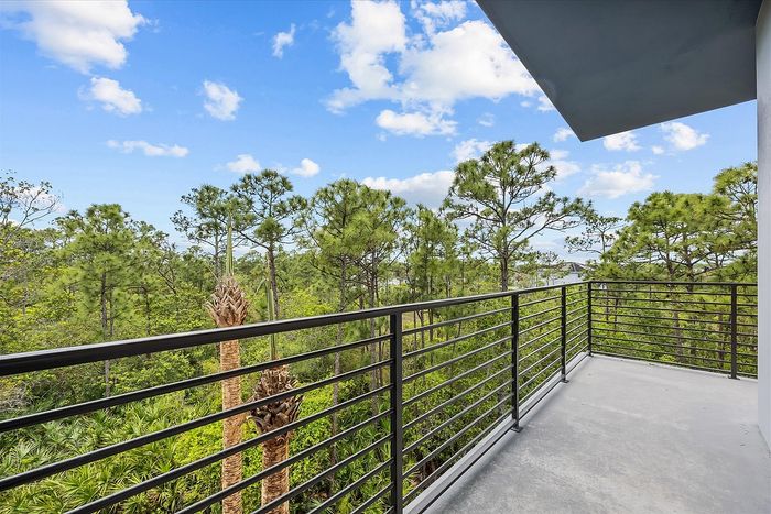 Charming balcony view of lush greenery and bright blue skies, perfect for enjoying a serene and scenic outdoor space.