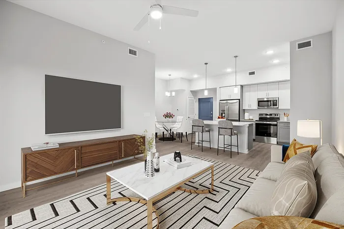 Chic and modern open-concept living area with stylish furnishings, a sleek dining space, and a contemporary kitchen with stainless steel appliances.