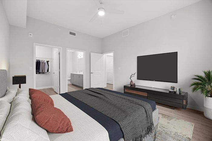 Luxurious bedroom with modern decor, featuring a cozy bed, elegant walk-in closet, and sleek en-suite bathroom, perfect for comfort and relaxation.