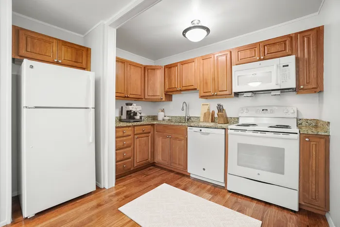 Charming kitchen with warm wood cabinets, modern appliances, and sleek granite countertops, perfect for culinary creativity.