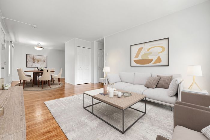Elegant open-concept living and dining area featuring sleek hardwood floors, modern furniture, and tasteful artwork.