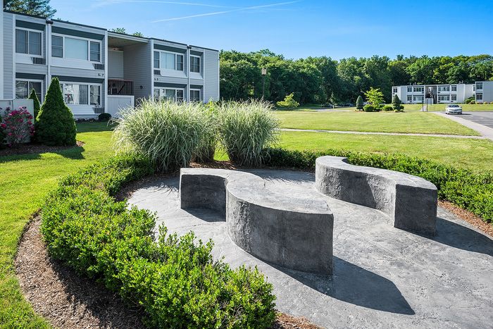 Inviting apartment exterior with lush green landscaping and contemporary design, enhancing a tranquil lifestyle.