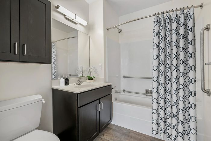 Modern bathroom featuring elegant fixtures, stylish cabinetry, and a patterned shower curtain for a contemporary feel.