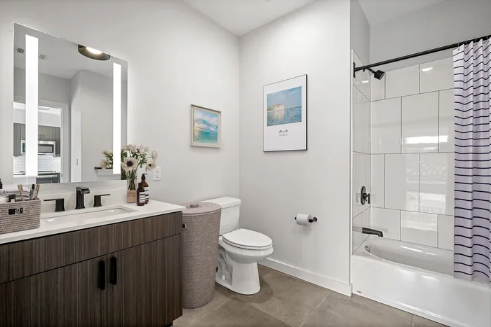 Elegant modern bathroom with sleek vanity, stylish wall art, and a chic shower curtain for a sophisticated look.