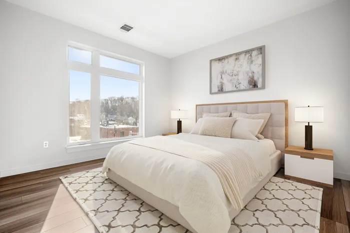 Bright and airy bedroom with a cozy bed, large window offering scenic views, and elegant decor creating a peaceful retreat.