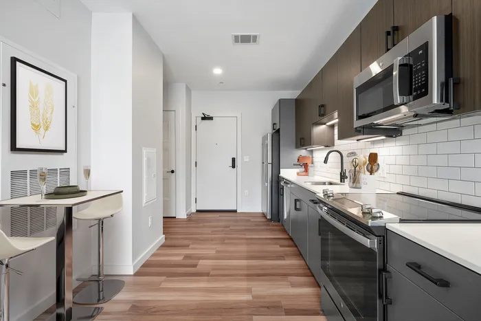 Modern kitchen with sleek stainless steel appliances, elegant cabinetry, and a cozy breakfast nook with bar stools.