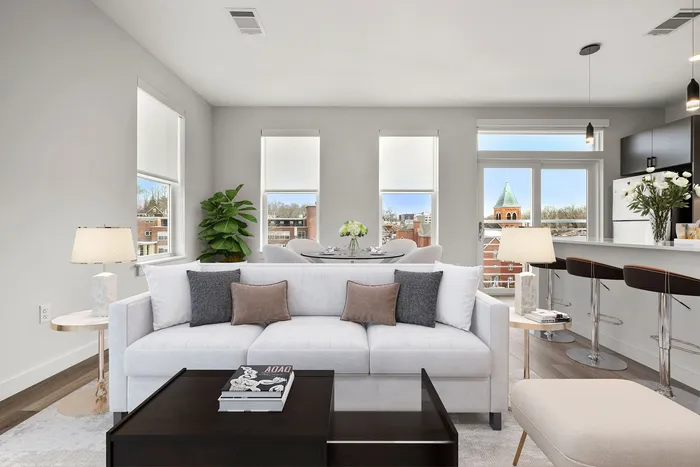 Bright and airy modern living area with a plush white sofa, stylish decor, and panoramic city views, perfect for entertaining.