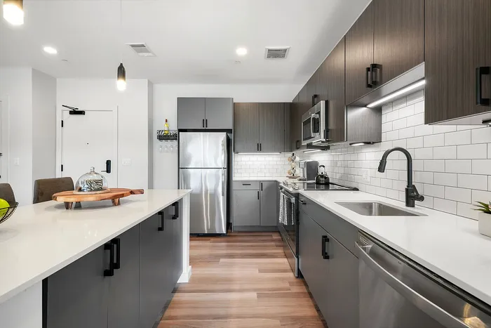 Sleek modern kitchen with stainless steel appliances, elegant cabinetry, and a spacious white island bench, perfect for entertaining.