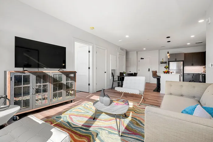 Modern open-plan living space with a sleek kitchen, cozy living area, and vibrant accents ideal for stylish urban living.