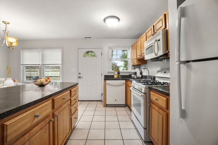 Bright and inviting kitchen with modern appliances, sleek countertops, and ample wooden cabinetry.