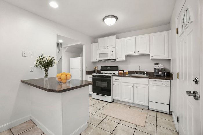 Bright, modern kitchen with sleek white cabinetry, stylish countertops, and stainless steel appliances.