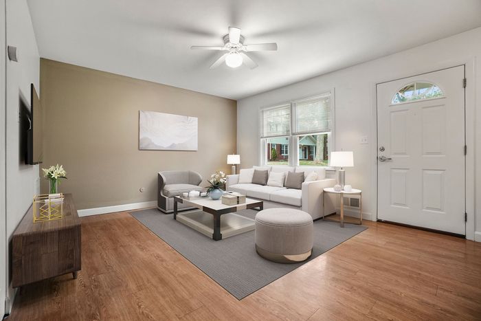 Bright and airy living room with elegant decor, featuring a comfortable white sofa, modern coffee table, and large windows providing natural light.