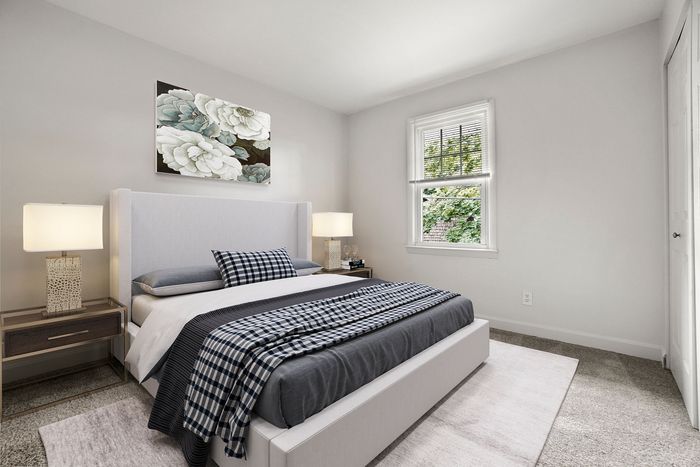 Elegant bedroom with modern decor, featuring a plush bed, stylish side tables, and soft lighting, complemented by a floral artwork on the wall and a scenic view through the window.