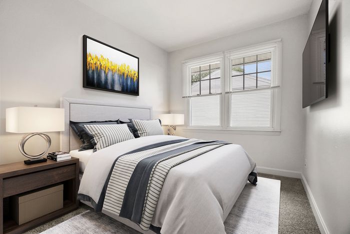 Bright and inviting bedroom with modern accents, featuring a comfortable bed, stylish artwork, and ample natural light through large windows.