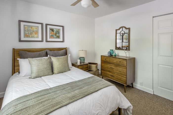 Cozy bedroom with modern wooden furniture, elegant decor, and soothing neutral tones, offering a tranquil retreat.
