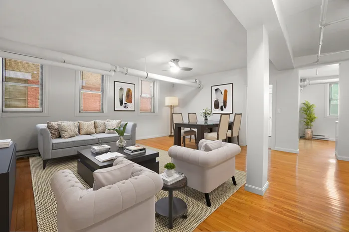Bright and inviting living space featuring plush seating, chic artwork, and elegant dining area with hardwood floors.