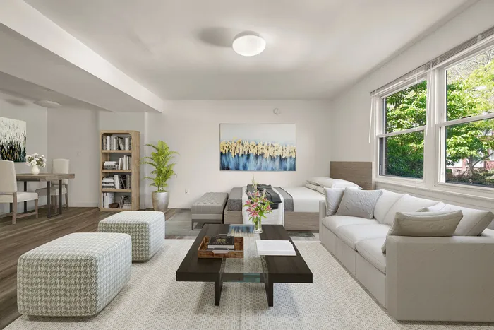 Inviting living room with plush gray sofas, chic decor, and large windows offering lush garden views, perfect for relaxation and entertainment.