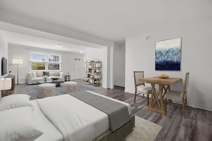 Inviting and modern open-concept living area with elegant decor, featuring a cozy bed, stylish seating, and a chic dining space. Natural light enhances the room's airy ambiance.
