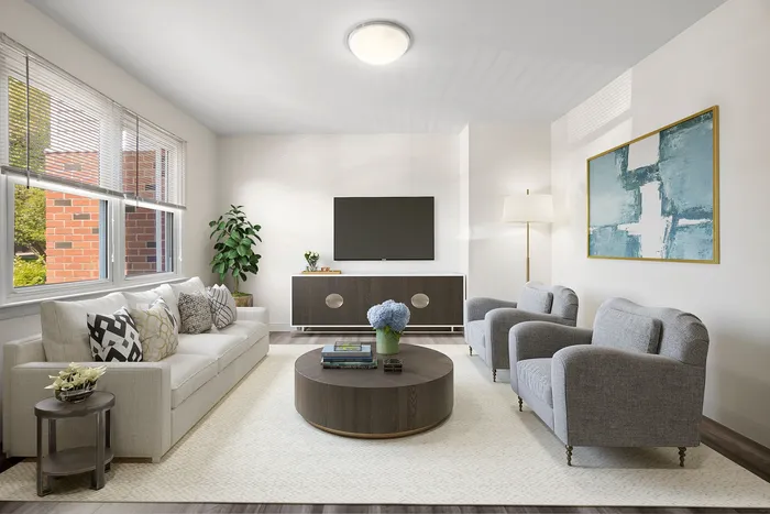 Bright and inviting living room featuring a modern aesthetic with cozy seating, elegant decor, and ample natural light through large windows.