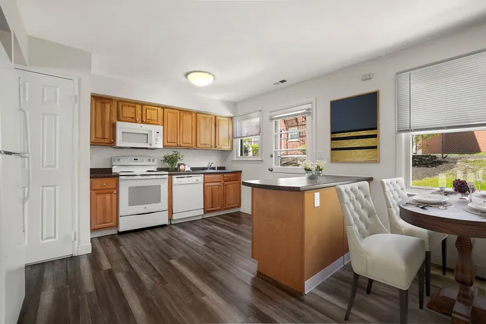 Inviting kitchen with natural wood cabinetry, modern appliances, and cozy dining area, perfect for home cooking and entertaining.