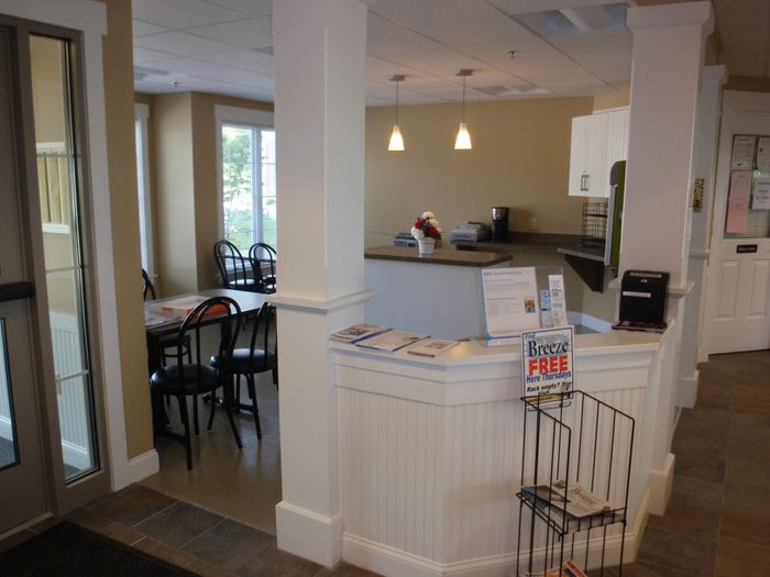 Inviting reception area featuring a cozy dining nook, modern lighting, and informational brochures.