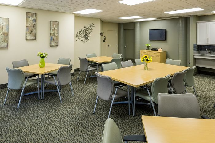 Elegant communal dining area with stylish tables, modern chairs, and vibrant floral decor, perfect for gatherings in a sophisticated setting.