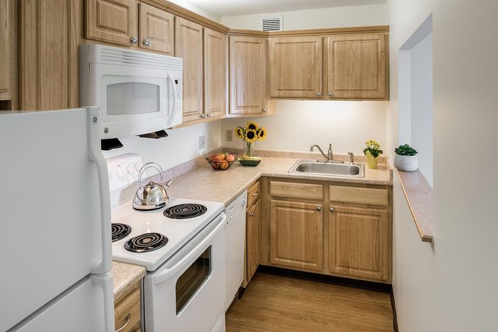 Charming kitchen with elegant wooden cabinets, modern appliances, and a cozy ambiance complete with vibrant decor.