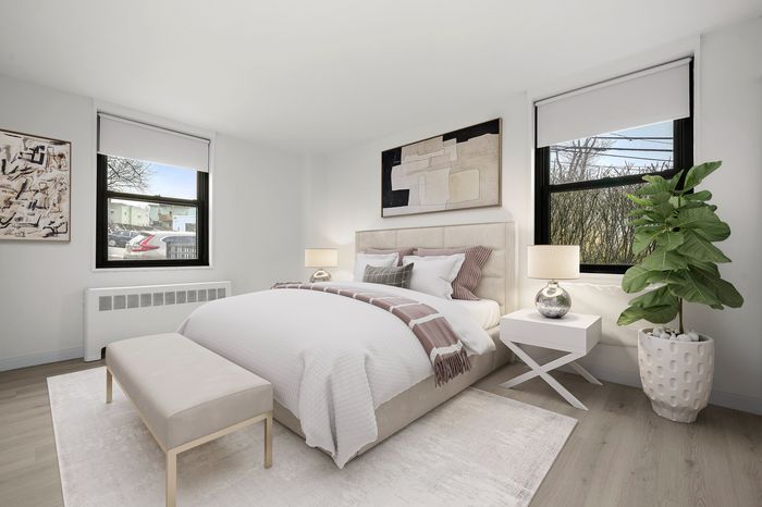 Bright and inviting bedroom with modern decor, featuring a cozy bed and two large windows allowing natural light to flood the space.