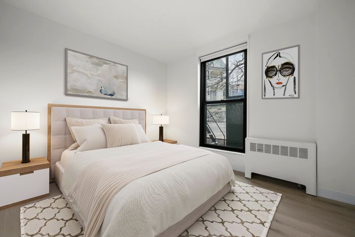Inviting bedroom featuring a plush bed with elegant linens, ambient lighting from stylish lamps, and chic wall art, creating a serene retreat.