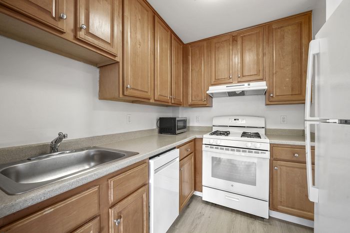 Contemporary kitchen with elegant wooden cabinets, sleek countertops, modern appliances, and a bright, spacious design.
