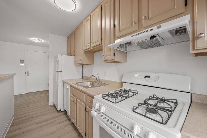 Bright and welcoming kitchen with modern beige cabinetry, sleek countertops, and a gas stove, perfect for stylish living.
