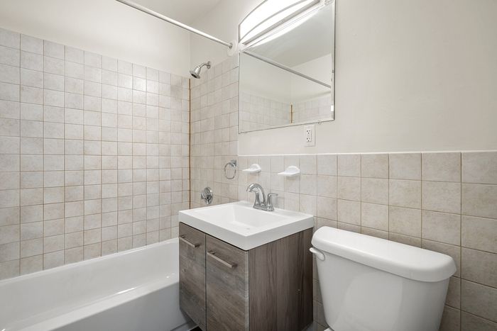 Bright and modern bathroom with sleek fixtures, elegant tile backsplash, and a stylish vanity.