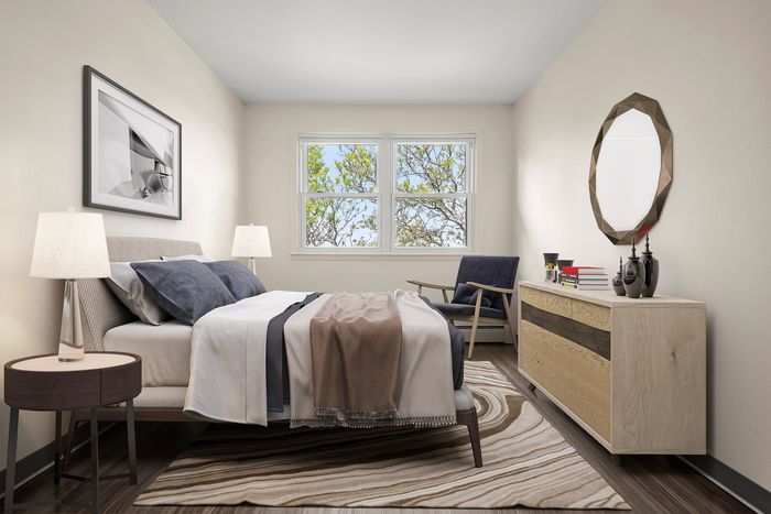 Inviting bedroom featuring elegant decor, large window with serene tree views, and modern furnishings for a tranquil retreat.