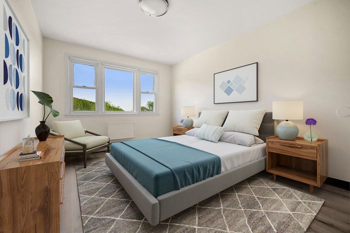 Elegant bedroom with large windows, modern decor, and stylish furniture, offering a serene and inviting atmosphere.