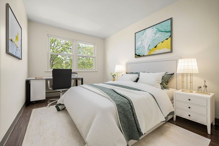Bright and inviting bedroom with modern decor, featuring a cozy bed, sleek desk by the window, and elegant art pieces.
