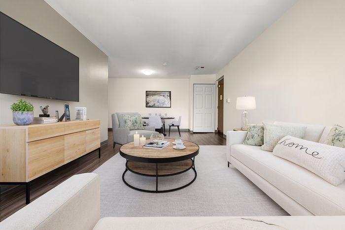 Elegant living room with modern furniture, sleek entertainment unit, cozy seating, and a chic coffee table, perfect for relaxation and entertaining.