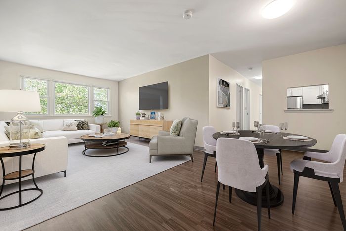 Bright and inviting living-dining space with modern furnishings, elegant decor, and large windows offering lush outdoor views.