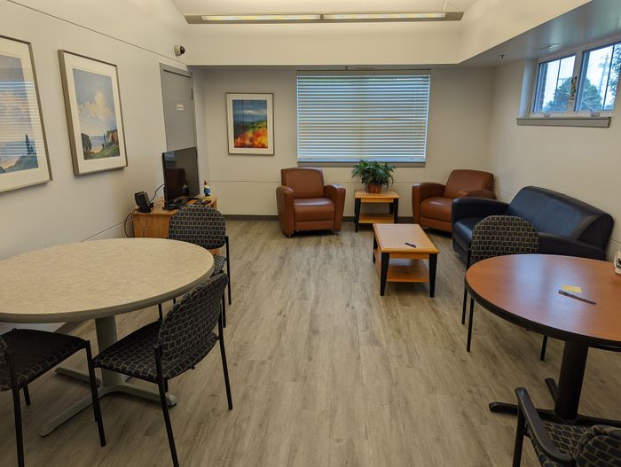 Inviting communal living area with modern furniture, charming decor, and large windows for natural light.