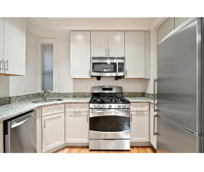 Contemporary kitchen featuring sleek stainless steel appliances, elegant granite countertops, and crisp white cabinetry.