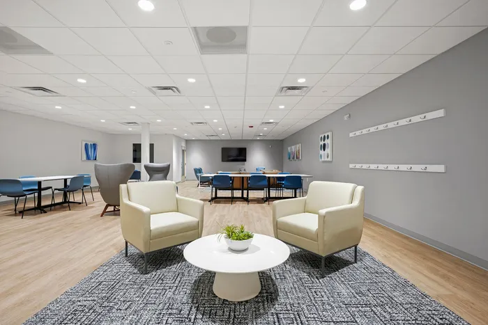 Elegant community room with modern seating, vibrant art, and ample natural light creates a welcoming atmosphere for gatherings.