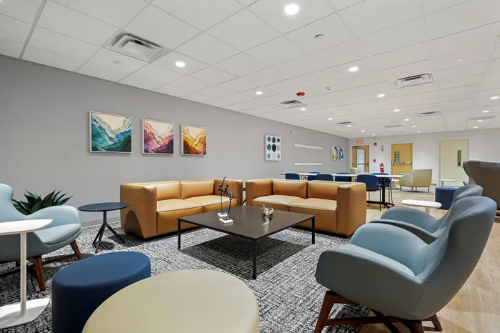 Modern lounge area with chic leather sofas, stylish armchairs, and vibrant abstract art on the walls.