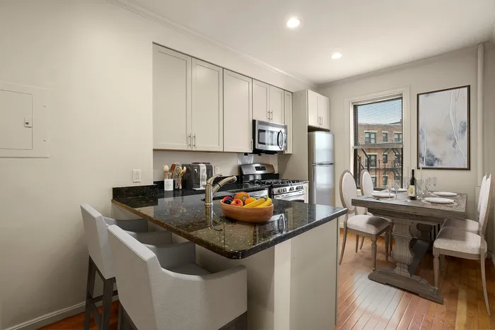 Inviting modern kitchen with sleek granite countertops, stainless steel appliances, and a cozy dining area perfect for gatherings.