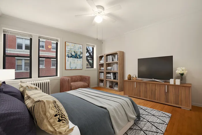 Elegant bedroom with large windows, cozy seating, stylish wooden flooring, and modern entertainment unit.