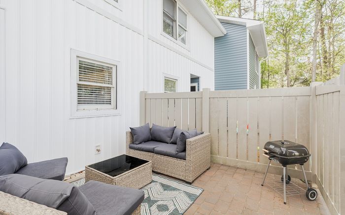 Charming outdoor patio with cozy seating and grill, perfect for relaxation and entertaining.